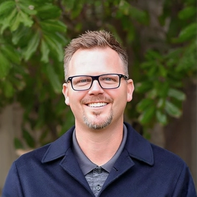 Chiropractor Ron Bittle Smiling Outdoors In Blue Polo